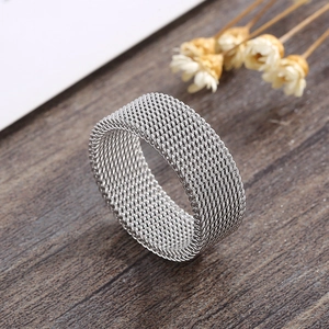 Macro detail of silver mesh weave texture on stainless steel wide band ring