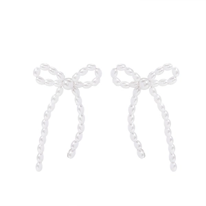 Detail view of bow-shaped drop earrings featuring white faux pearls and elegant tassels