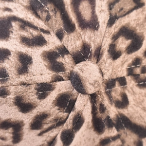 Macro shot of leopard print velvet baseball cap crown with button and stitching detail
