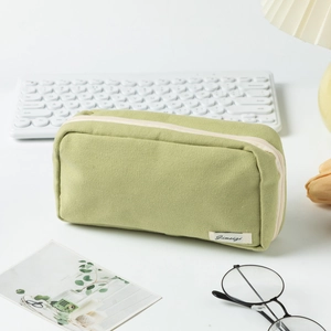 Avocado green canvas pencil case with zipper closure on desktop with stationery