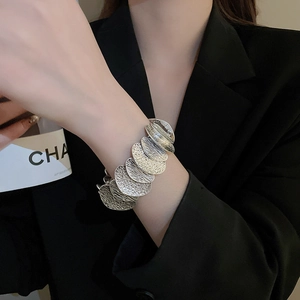 Detail of silver round link bracelet with hammer texture and brushed finish on wrist