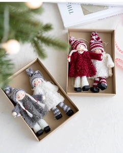 Detail of handmade wool felt angel ornaments in gift box with festive branch decor