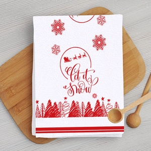 Close-up of Christmas waffle weave kitchen towel with Let it snow print on wooden board