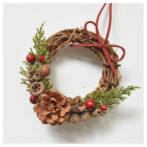 Close-up of handmade Christmas wreath with pine cones, red berries and green pine needles