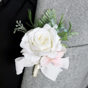 European style white rose boutonniere with green leaves on grey suit lapel for weddings