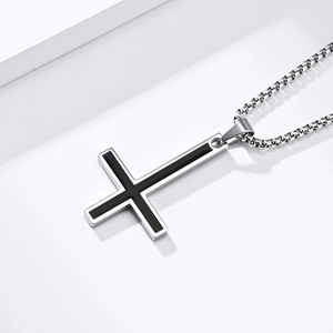 Close-up of inverted cross pendant with black enamel on a silver chain necklace