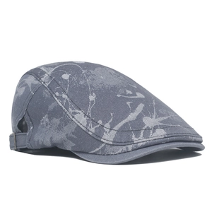 Detail of dark grey newsboy cap with abstract texture and adjustable metal side buckle