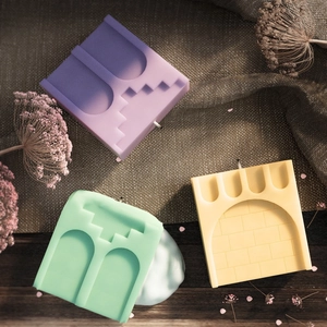 Detail of castle-shaped silicone candle molds with textured roman palace architecture