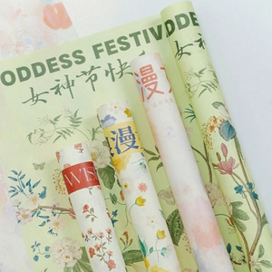 Detail of light green floral gift wrapping paper with Goddess Festival gold lettering