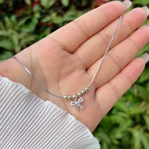 Handcrafted bow necklace with 18K gold plated beads and sparkling cubic zirconia stones