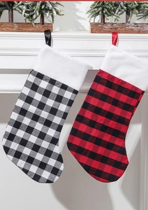 Détails de chaussettes de Noël à carreaux rouges et noirs sur un manteau de cheminée