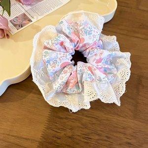 Détail du chouchou floral avec bord en dentelle sur un fond en bois rustique