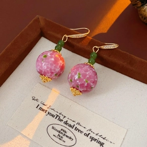 Details von Retro-Ohrringen mit Blumen-Glaskugeln in Rosa und grünen Perlen