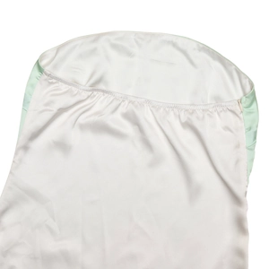 Détail d'une robe bustier en satin crème avec bordure vert clair et fermeture éclair invisible