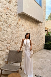Detail of white halter neck maxi dress with elegant ruched waist and front cutout