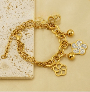 Détail du bracelet en acier inoxydable plaqué or 18k avec fleurs évidées et strass pavés