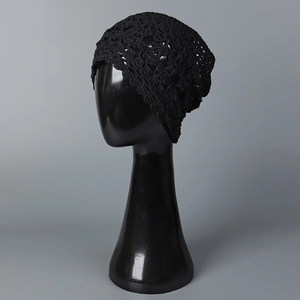 Primer plano del gorro negro calado que muestra los detalles del tejido de ganchillo