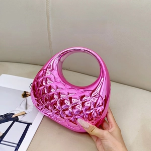 Detail of metallic pink acrylic clutch bag featuring embossed diamond patterns and round handle