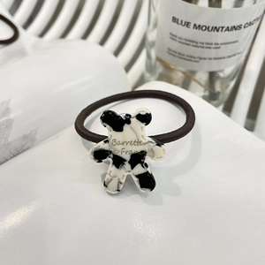 Elastic hair tie with cute cow-print bear pendant and gold lettering on white book
