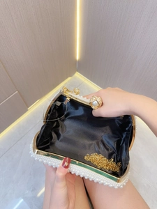Detail view of pearl evening bag with gold chain strap and elegant black satin lining