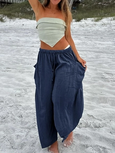 Detail of navy blue wide-leg linen pants featuring elastic drawstring waist and side pockets