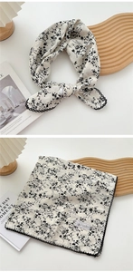 Close-up of floral cotton linen square scarf with wavy lace edge and fashion label detail