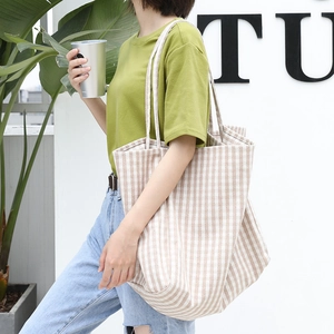 Large beige striped canvas tote bag for women showing natural drape and spacious design