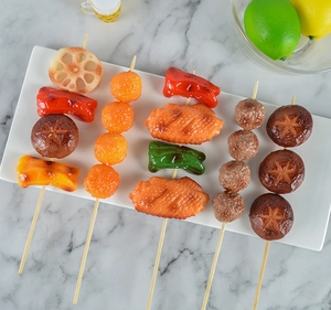 Dettaglio di spiedini barbecue artificiali su piatto in ceramica per scena di cucina