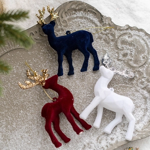 Three velvet Christmas reindeer ornaments with glitter antlers on decorative snow tray