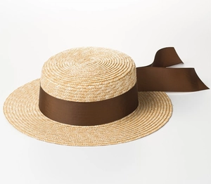 Dettaglio del cappello in paglia di grano con texture naturale e ampio nastro marrone