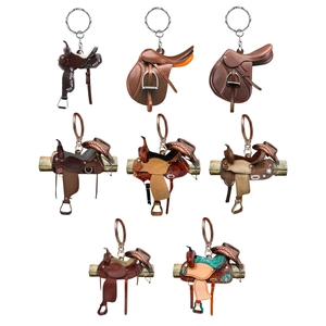 Collection of Western saddle acrylic keychains with cowboy hat charms on wood display
