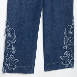 Jean large bleu foncé avec patchs étoile brodés et détails d'usure tendance