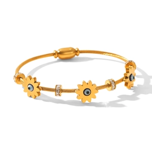 Detail of gold twisted cable bangle with evil eye sunflower charms and crystal beads