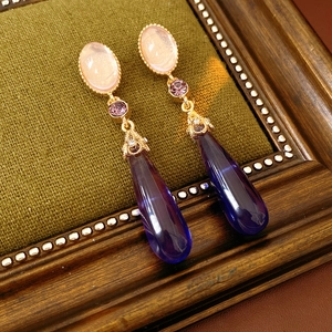 Vue macro de boucles d'oreilles vintage avec pierres ovales roses et pendentifs violets