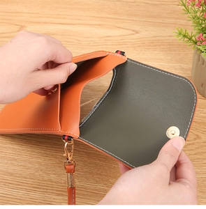 Vue de dessus du sac pour téléphone en cuir orange avec détails dorés et compartiment