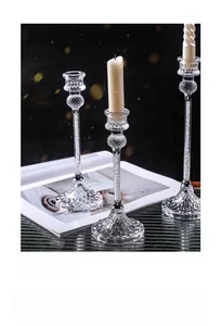 Close-up of three modern glass candlesticks with crystal bead filling and spiral candles