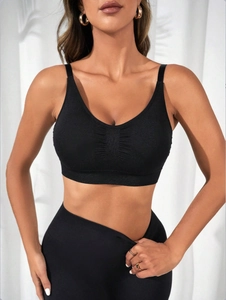 Detail of black seamless V-neck sports bra with ruched chest design and wide straps