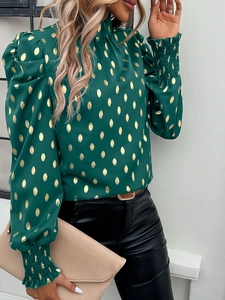 Detail of green long sleeve blouse with gold polka dots and elastic pleated cuffs