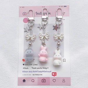 Plush bunny keychains in pink, grey and white with star charms and bows for bags