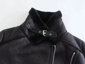 Detail of black double-sided jacket showing shearling texture and metal zipper