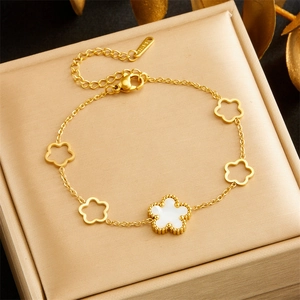 Detail of 18K gold stainless steel chain bracelet with white shell flower charms