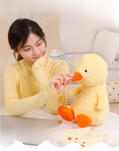 Close-up of a soft yellow plush duck toy held by a woman in a cozy home setting