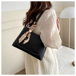 Détail du grand sac cabas noir en similicuir avec foulard en soie porté par un mannequin