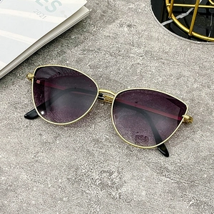 Fashionable cat-eye sunglasses with gold metal frames and purple gradient lenses on stone background