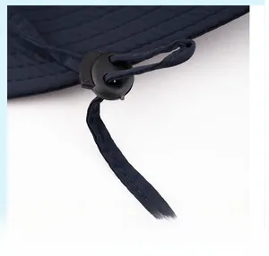 Detail of adjustable black buckle and strap on dark blue outdoor sun hat fabric