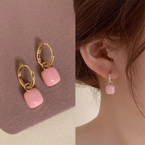 Vue détaillée des boucles d'oreilles dorées avec pendentifs en résine rose pastel