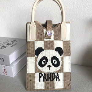 Close-up of knitted panda tote bag with checkered pattern and leather buckle detail