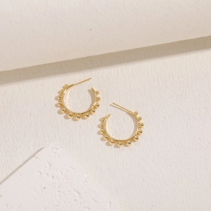 Detail of 14K gold plated hoop earrings with polished spheres and minimalist design