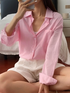 Detail of pink linen long sleeve shirt with chest pocket and buttons in home setting