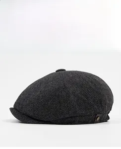 Detailed side view of dark grey herringbone newsboy cap with brown leather label accent